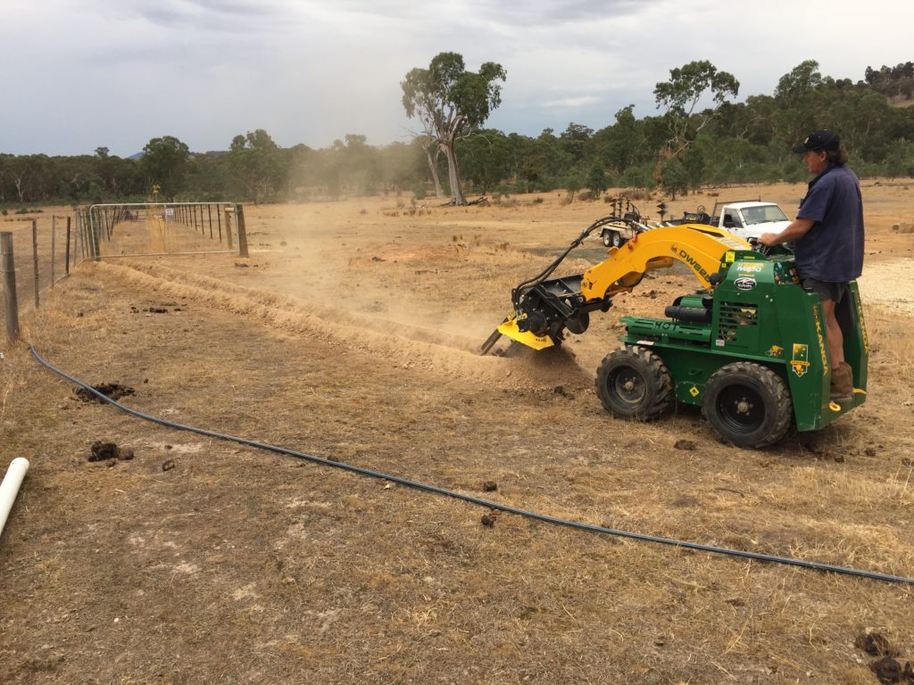 Man operating trench digger